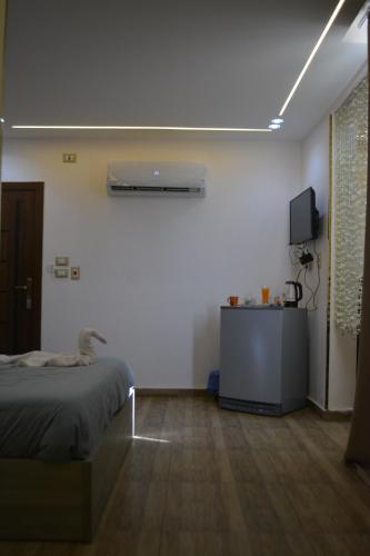 a bedroom with a bed and a tv on a wall at king pyramids in Cairo