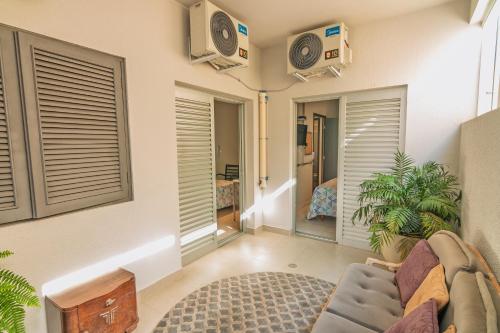 Una sala de estar con un sofá y un televisor. en K3 Residence Taquaral, en Campinas