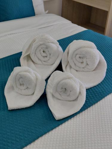 a group of towels sitting on top of a bed at Residencial Tropicália AL in Praia da Barra