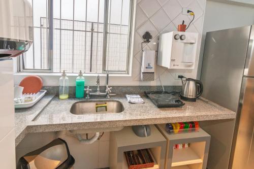 a kitchen counter with a sink in a kitchen at K3 Residence Copa & Cozinha in Campinas