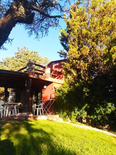 a house with a table and chairs in a yard at Posada de Nono in Nono