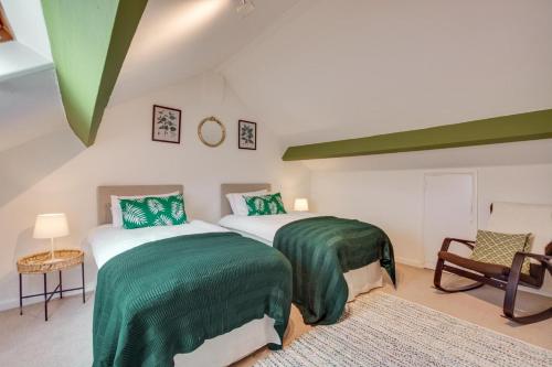 two beds in a room with green and white at 1 Rose Cottage in Hawes