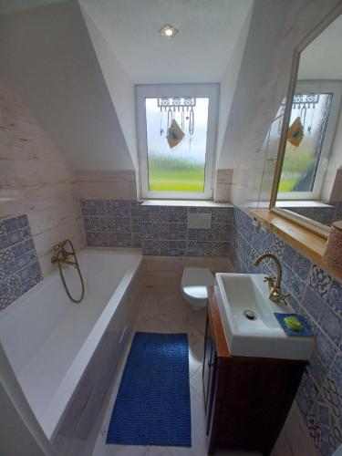 a small bathroom with a tub and a sink at Hikeslovakia House in Mlynčeky