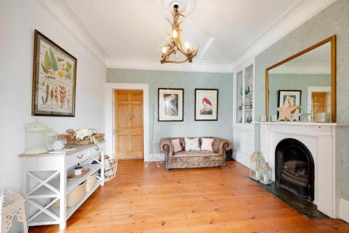 a living room with a fireplace and a couch at Bloomfield House in Braunton