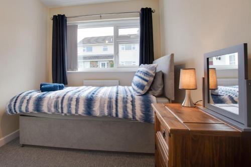 桑德斯富特Ashwood的一间卧室，配有一张床、一扇窗户和一台电视