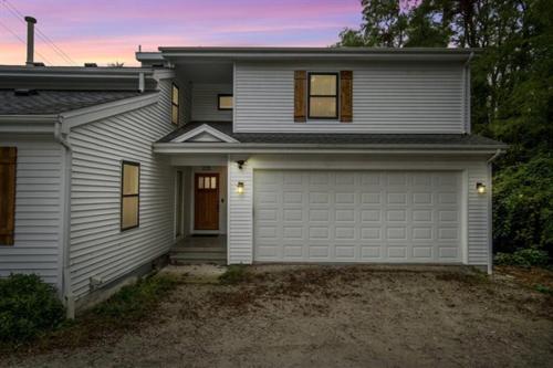 a white house with a garage at The Newly Built Custom Townhome by Granger Gardens in Ann Arbor