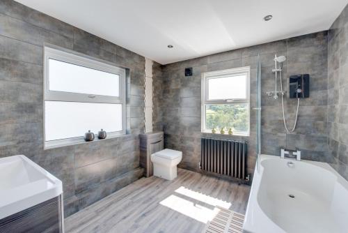 une salle de bain avec une baignoire, des toilettes et un lavabo dans l'établissement Sandpiper Cottage, à Saundersfoot