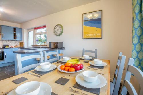 a dining room table with a bowl of fruit on it at 3 Bro Terfyn in Morfa Nefyn