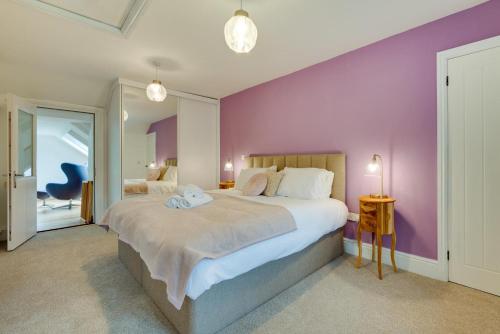 Un dormitorio con una cama grande con una pared morada. en Hafod Gau, en Cemmaes