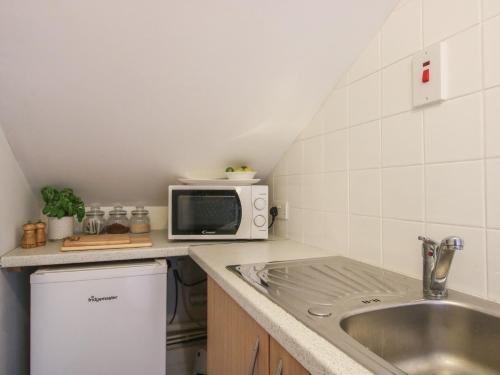 a kitchen with a sink and a microwave at Old Forge Apartment in Wolverley