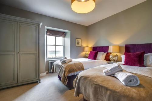 a bedroom with two beds and a window at Orchard Cottage in Newlyn