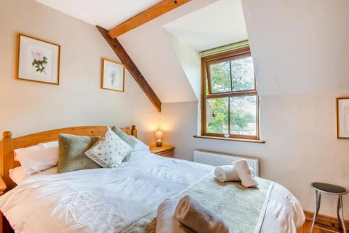 a bedroom with a bed and a window at Chestnut Cottage in Manorbier