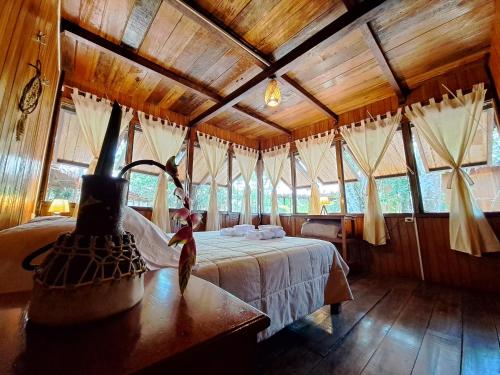a bedroom with a bed in a room with windows at Andean Wings Sotupa Eco Lodge in Puerto Maldonado