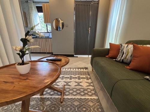 a living room with a green couch and a table at Kampala Kyanja Expatriate Living in Kampala