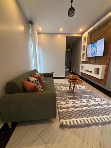 a living room with a green couch and a table at Kampala Kyanja Expatriate Living in Kampala