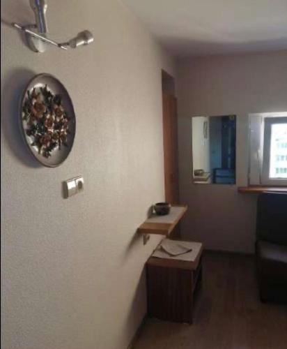 a living room with a clock on the wall at 3 kambariu butas in Klaipėda