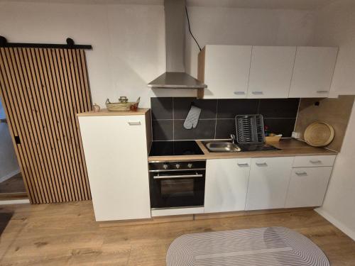 a small kitchen with white cabinets and a stove at Wildstein - Rote Wand in Bayrischzell