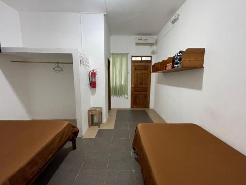 a small room with two beds and a door at Casa de Huespedes "Darling" in Puerto Baquerizo Moreno