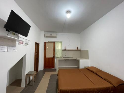 a bedroom with a bed and a television in a room at Casa de Huespedes "Darling" in Puerto Baquerizo Moreno