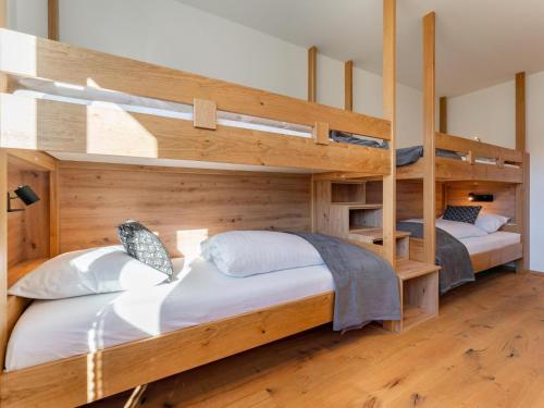 two bunk beds in a room with wooden walls at Chalet Kolibri in Sankt Lambrecht
