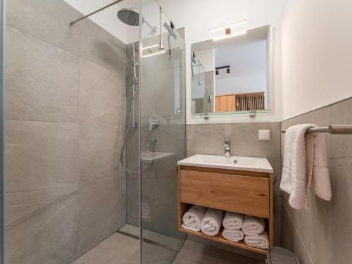 a bathroom with a shower and a sink and a mirror at Chalet Kolibri in Sankt Lambrecht