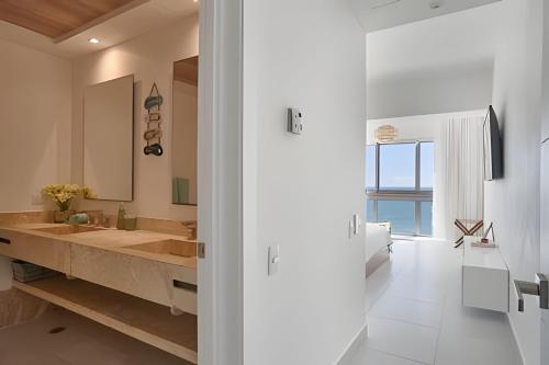 Un baño con un lavabo grande y un espejo grande. en Caribbean Breeze beachfront apartment, en La Puntica de Juan Dolio