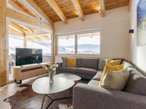 a living room with a couch and a tv at Grebenzen Lodge Pabstin 36B in Sankt Lambrecht