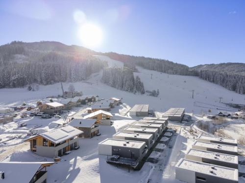 a resort in the snow with the sun in the background at Grebenzen Lodge Pabstin 36B in Sankt Lambrecht