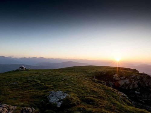 a house on the top of a hill with the sunset at Chalet Kolibri in Sankt Lambrecht