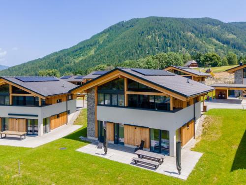 an aerial view of a house with mountains in the background at Grebenzen Top Chalet Mazzel in Sankt Lambrecht