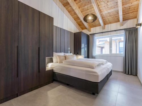 a bedroom with a large bed with a wooden wall at Grebenzen Top Chalet Mazzel in Sankt Lambrecht