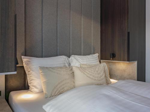 a white bed with white pillows in a bedroom at Grebenzen Top Chalet Mazzel in Sankt Lambrecht