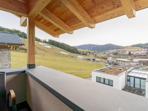 a view from the balcony of a house with a wooden roof at Grebenzen Lodge Hirsch in Sankt Lambrecht