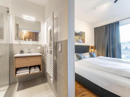 a bedroom with a bed and a sink and a mirror at Grebenzen Lodge Hirsch in Sankt Lambrecht