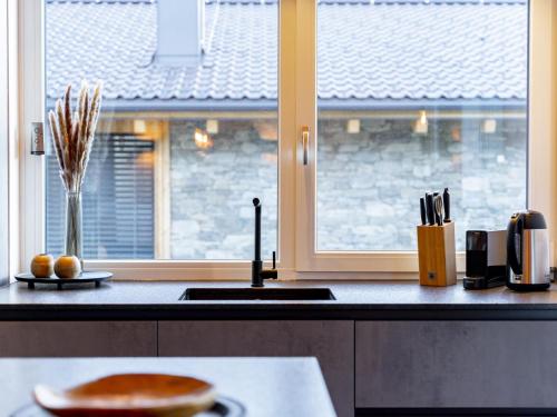 a kitchen with a counter with a window and a sink at Grebenzen Lodge Hirsch in Sankt Lambrecht