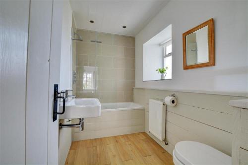 a bathroom with a sink and a bath tub at The White Cottage in Saint Winnow
