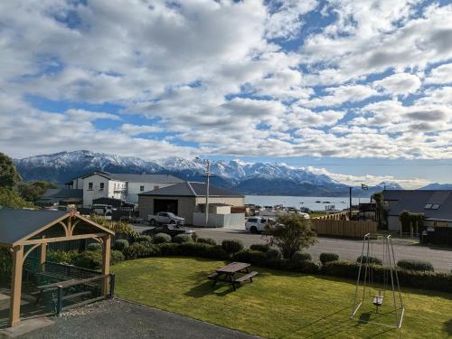 a park with a playground with mountains in the background at The Peninsula Kaikoura in Kaikoura