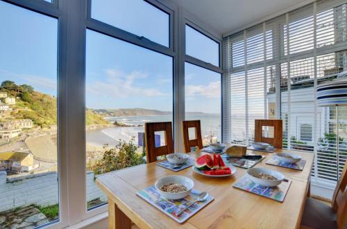 a dining room with a table with a view of the ocean at The Gulls in Looe