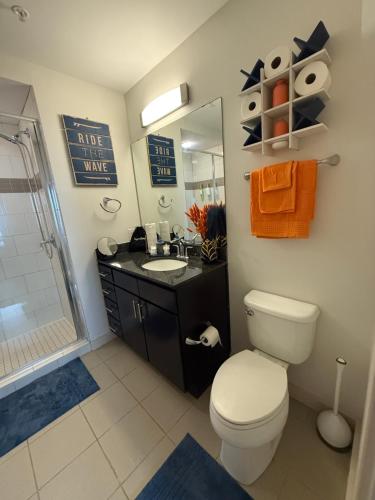 a bathroom with a toilet and a sink and a shower at Luxury Midtown High-rise Oasis! in Atlanta