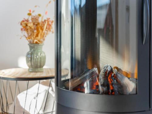 a fireplace with a vase of flowers and a table at Grebenzen Lodge Prinz in Sankt Lambrecht