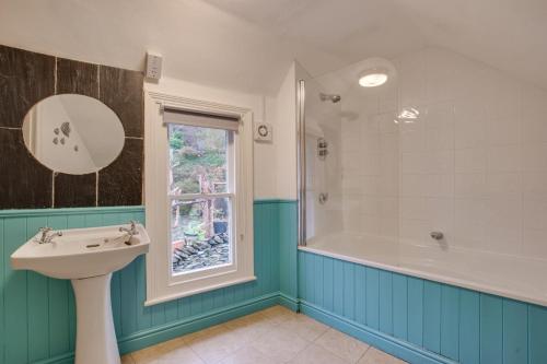 a bathroom with a sink and a tub and a window at Bryn Hyfryd in Penmaenpool