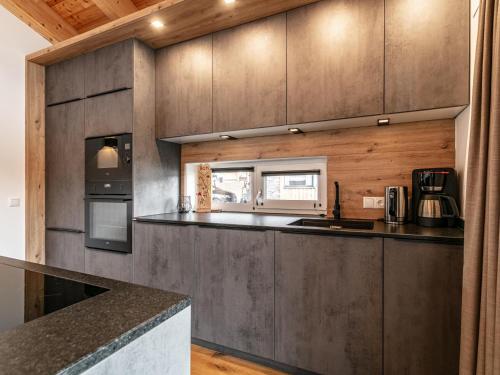 a kitchen with wooden cabinets and a counter top at Grebenzen Lodge 35 in Sankt Lambrecht
