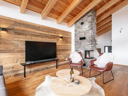 a living room with a television and a table and chairs at Grebenzen Lodge 35 in Sankt Lambrecht