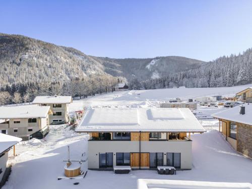 a house in the snow with a mountain in the background at Grebenzen Eiszeit Lodge in Sankt Lambrecht
