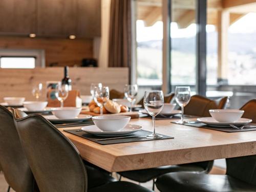 a wooden table with chairs and wine glasses on it at Grebenzen Lodge 35 in Sankt Lambrecht