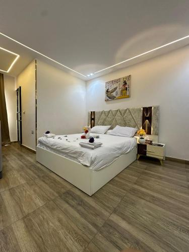 a bedroom with a large white bed and a desk at king pyramids in Cairo