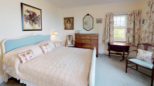 a bedroom with a bed and a desk and a chair at Trefaes in Abersoch
