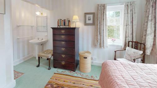 a bedroom with a bed and a sink and a dresser at Trefaes in Abersoch