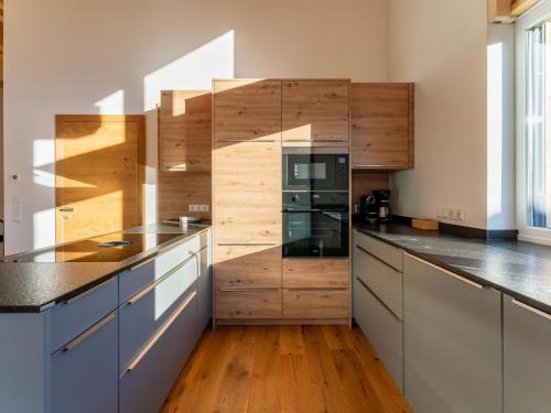 a large kitchen with wooden walls and wooden counters at Grebenzen Eiszeit Lodge in Sankt Lambrecht