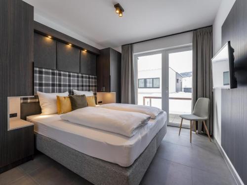 a bedroom with a large bed and a large window at Alpenchalet Lambert in Sankt Lambrecht